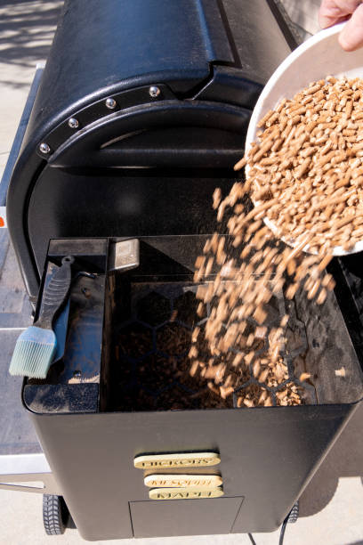 istock Using a bucket to pour hardwood pellets into a smoker 1406748061