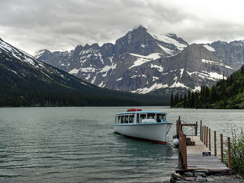 Passenger boat in Glacier Park with surrounding mountains.