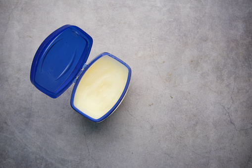 top view of petroleum jelly in a container on black background .