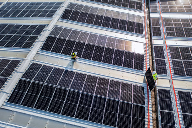 istock Team of engineers using technology while installing solar panels on a roof of warehouse. 1406753499