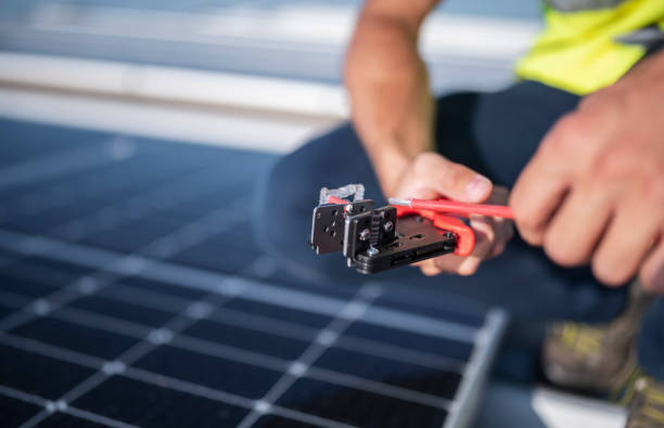 istock Unrecognizable worker using special pliers to cut wire on solar panels. 1406753506