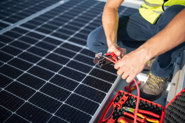 istock Unrecognizable worker using special pliers to cut wire on solar panels. 1406753515