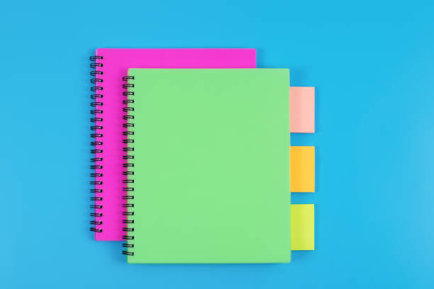 istock Top view of colourful notebooks and sticky notes on blue table background. 1406755584