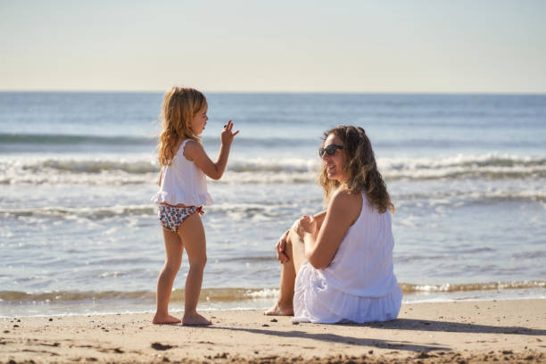 istock a woman with her daughter by the seashore 1406755598