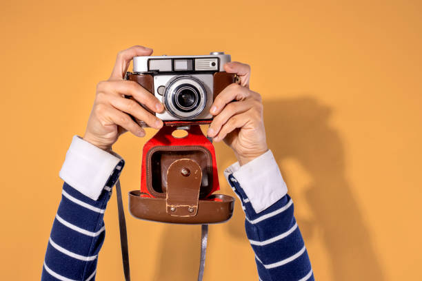 istock Arms up holding vintage camera isolated background 1406758010