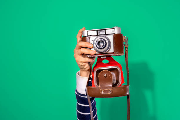 istock Arms up holding vintage camera isolated background 1406758013