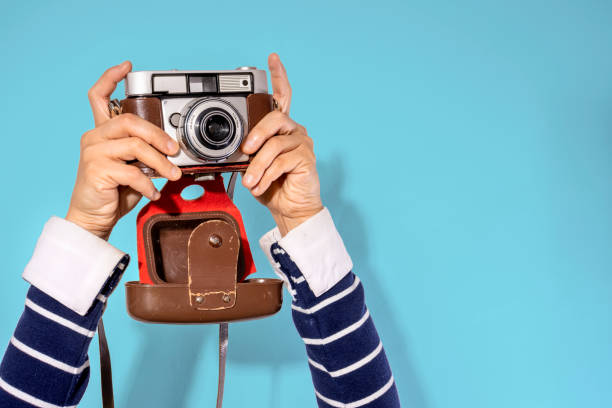 istock Arms up holding vintage camera isolated background 1406758015