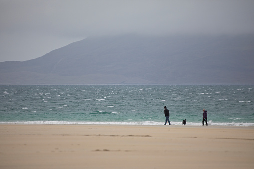 Luskentyre, Isle of Harris, Outer Hebrides, Scotland, United Kingdom - April 16, 2022: group of people walking on Luskentyre beach