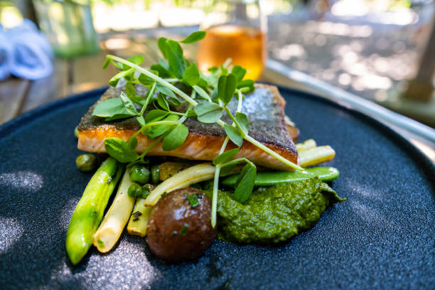 Pan Fried Rainbow Trout with Vegetables Pan Fried Rainbow Trout with Yellow Beans, New Potatoes, Sweet Peas, New Potatoes and Garnished with Pea Sprouts trout photos stock pictures, royalty-free photos & images