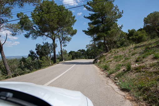 Traveling by car in sunny weather on the serpentine roads of Mallorca.