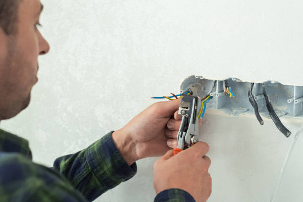 istock Electrician mounts a new socket on a white wall. Renovation process in a new apartment 1406763165