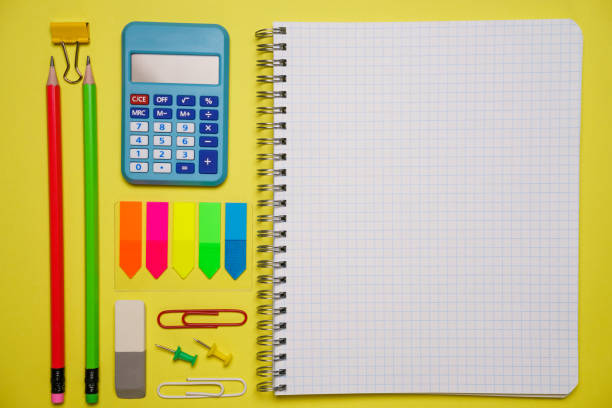 Notebook with a pen and colorful notes on a blue and orange background. Colorful paper clips. Back to school concept. Copy space