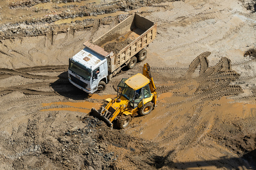 Wheel loader clears the site during excavation work on a construction site.Excavator with a front bucket removes the soil for backfilling at the construction site.Construction equipment for earthworks