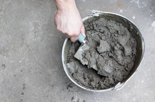 istock Mixing of concrete mortar.The builder prepares the cement mortar using a construction trowel.Plaster mortar in a bucket 1406766056