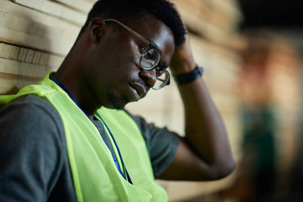 istock Close up of distraught black warehouse worker thinking of something. 1406766069