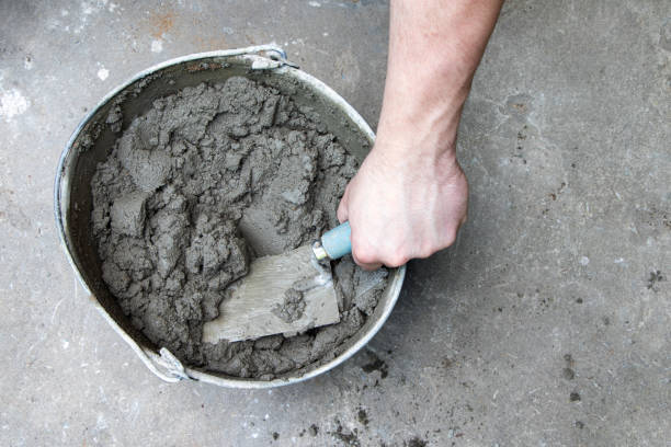 istock Mixing of concrete mortar.The builder prepares the cement mortar using a construction trowel.Plaster mortar in a bucket 1406766298