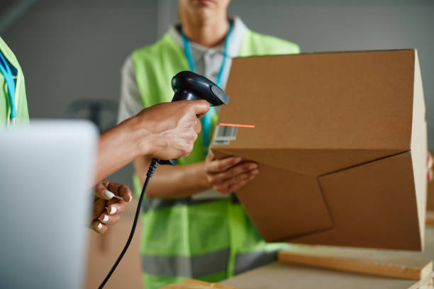 istock Close up of workers preparing packages for shipment and scanning labels at distribution warehouse. 1406767400