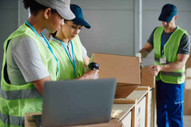 istock Warehouse worker and he colleagues scanning packages while preparing shipment at storage compartment. 1406767401