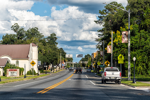 Newberry, USA - October 4, 2021: Small town in north Florida countryside and house buildings on street road with first baptist church and high school signs