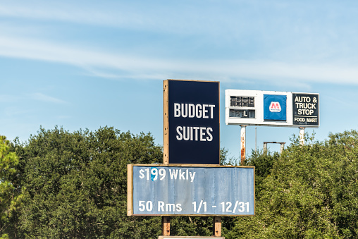 Tampa, USA - October 4, 2021: Road street interstate highway i75 in Tampa, Florida with billboard advertisement text sign for Budget Suites hotel motel with cheap rates and Marathon gas station
