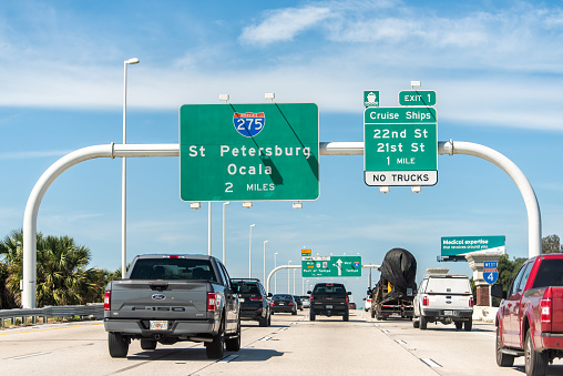 Tampa, USA - October 4, 2021: Road street interstate highway green sign from i75 for Port of Tampa, Cruise Ships, St Petersburg and Ocala in Florida with text and cars in traffic point of view
