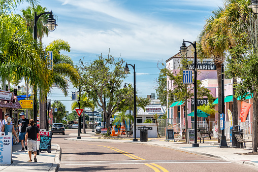 Tarpon Springs, USA - October 4, 2021: Florida Greek fishing village town Dodecanese boulevard street road with signs for stores shops and aquarium and people on sidewalk