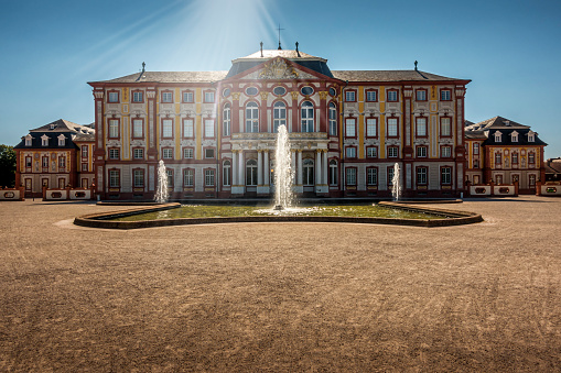 Bruchsal, Germany - June 30, 2022: Baroque style castle with fountain in the public park in Bruchsal in Germany.
