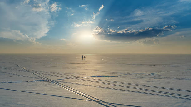 istock The two people with backpacks going trough the snow field 1406770174