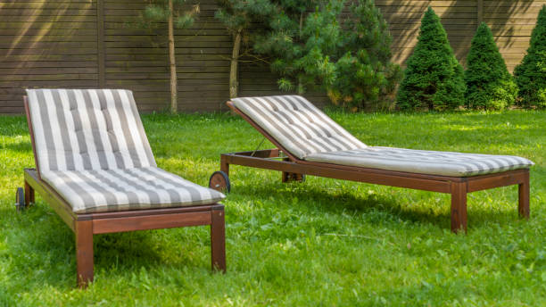 istock Lounge chairs on the backyard in a beautiful garden. Two empty sunbeds on the grass. 1406773239