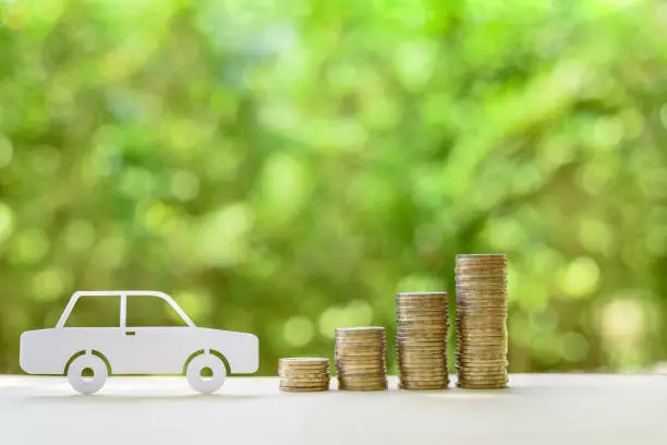 Photo of Used and second hand vehicle / car or auto loan, financial concept : Sedan car and rows of coins on a table, depicts money loan or borrowing fund to buy a new or old car for personal or individual use