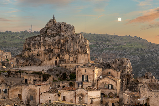 Sunset and full moon over famous cave church of Saint Mary of Idris im Matera, Italy