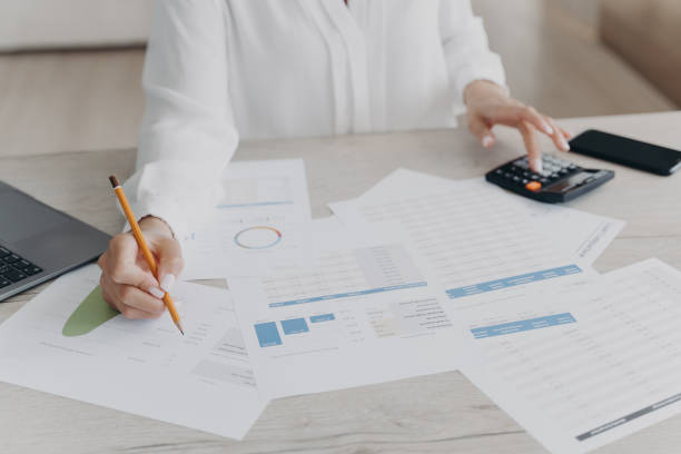 istock Female analyzing company statistics, calculates expenses, taxes before paying at workspace, close-up 1406777223