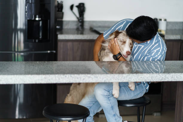 istock Young man hugging dog at home 1406777384