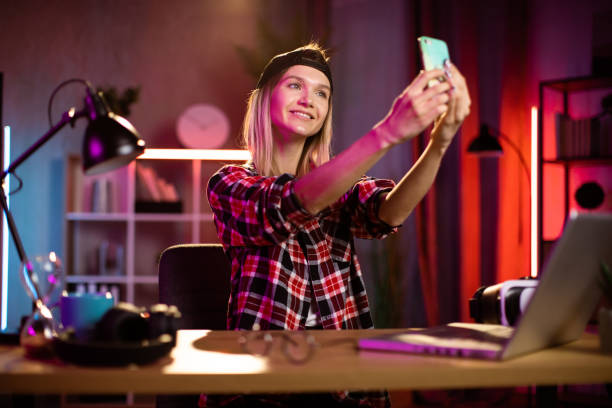 istock Attractive caucasian woman using modern cell phone for taking selfie. 1406778415