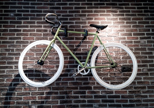 A bicycle hung next to a brick wall as a decoration element