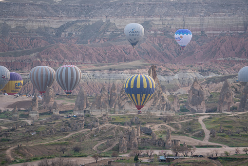 CAPPADOCIA - APRIL 15, 2019 :  tourists hot air balloons flying in morning above Goreme ,Cappadocia,  Turkey