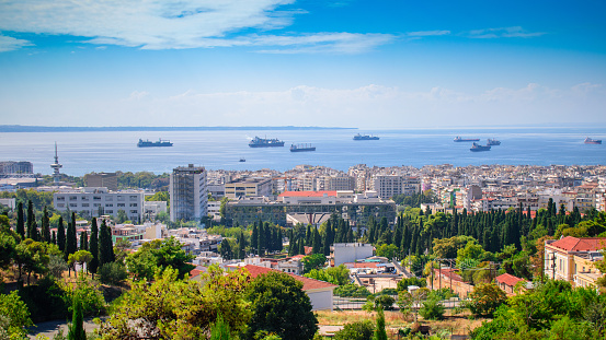 Group of ships in the gulf of Thessaloniki, Greece, on a sunny sky with white clouds. Thessaloniki is the second largest city in Greece and the capital of Greek Macedonia. panoramic view from Ano Poli