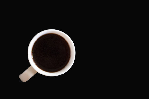 Black coffee in white mug isolated on black background. Abstract concept.