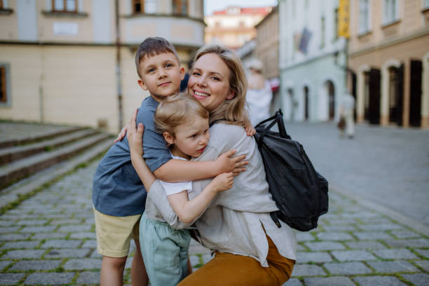 Young mother and little children smiling confident hugging each other standing at street A young mother and little children smiling confident hugging each other standing at street three way kiss stock pictures, royalty-free photos & images