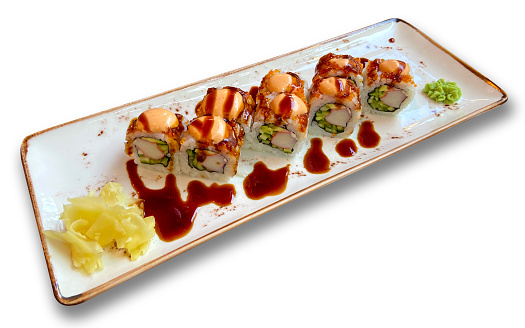 A black plate is presented on a table, featuring a selection of sushi rolls arranged impeccably.