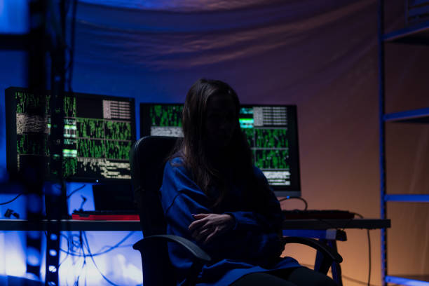 istock Anonymous hacker woman by computer in the dark room at night, cyberwar concept. 1406786058