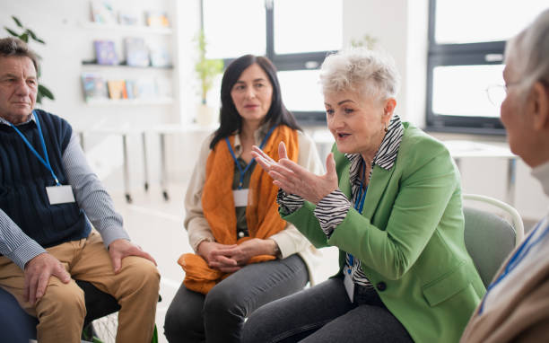 istock Group of senior people sitting in circle and discussing some problems together during therapy session 1406787037