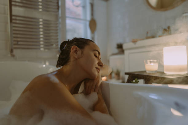 Young woman enjoying aromatherapy while taking a bath stock photo