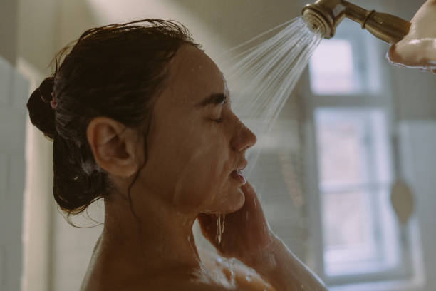 istock Young woman washing her face while taking a bath 1406788525