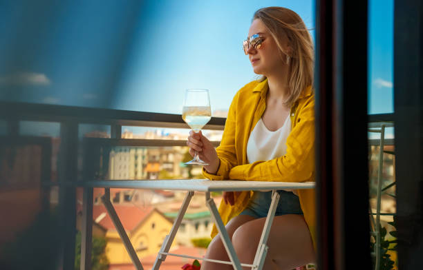 istock Woman with white wine enjoys her vacations on the balcony. 1406789804
