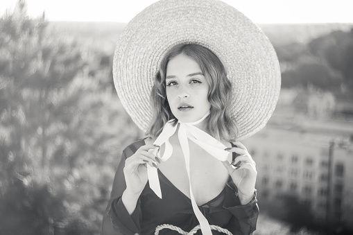 Black and white portrait of a stylish girl posing against the background of the city.