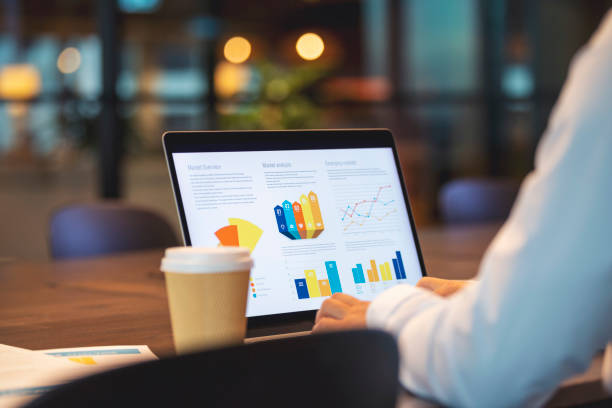 close up of businessman using a laptop with graphs and charts on a laptop computer. - dashboard imagens e fotografias de stock