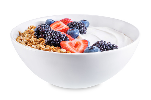 Fresh breakfast with greek yogurt nuts oatmeal granola with berries in a bowl on a white isolated background. the toning. selective focus