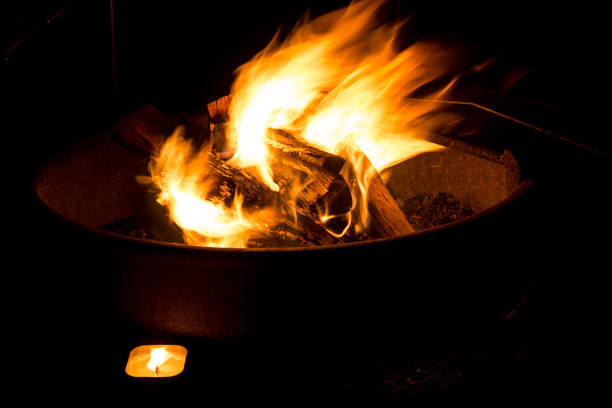 Burning flame at the camp fire ring during camping at night time