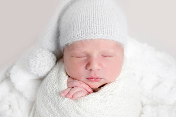 istock Newborn baby in white wrap laying on basket 1406797619